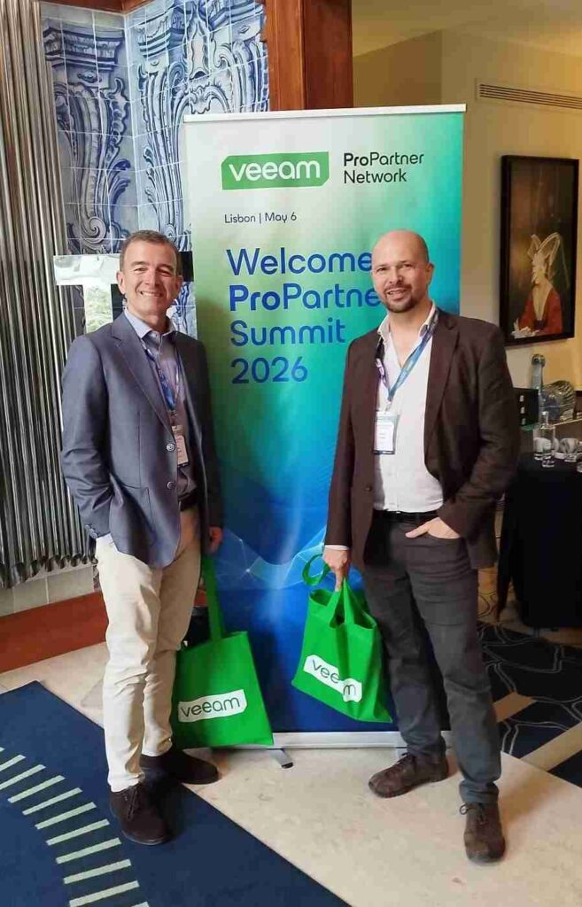 Integrantes del equipo de Ar en la entrada del Veeam ProPartner Summit 2026 en Lisboa, junto al banner de bienvenida del evento.