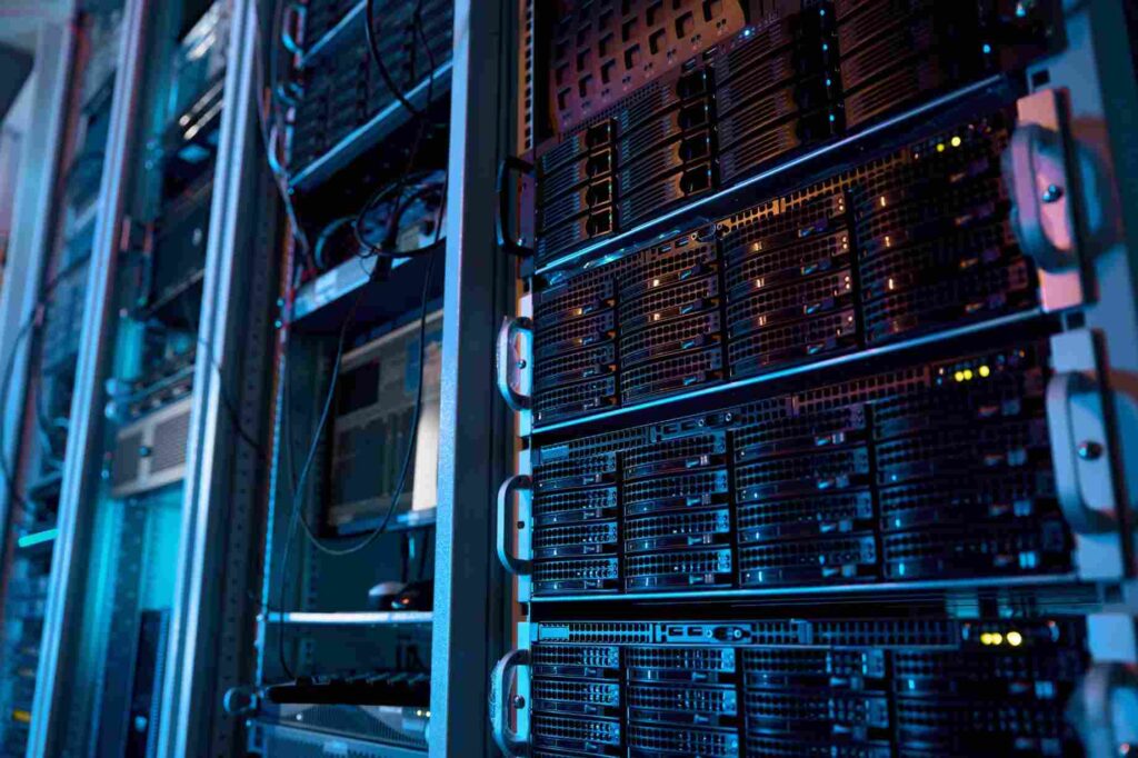 Racks de servidores físicos iluminados en azul dentro de un centro de datos, representando la infraestructura on-premise de un entorno de nube híbrida.